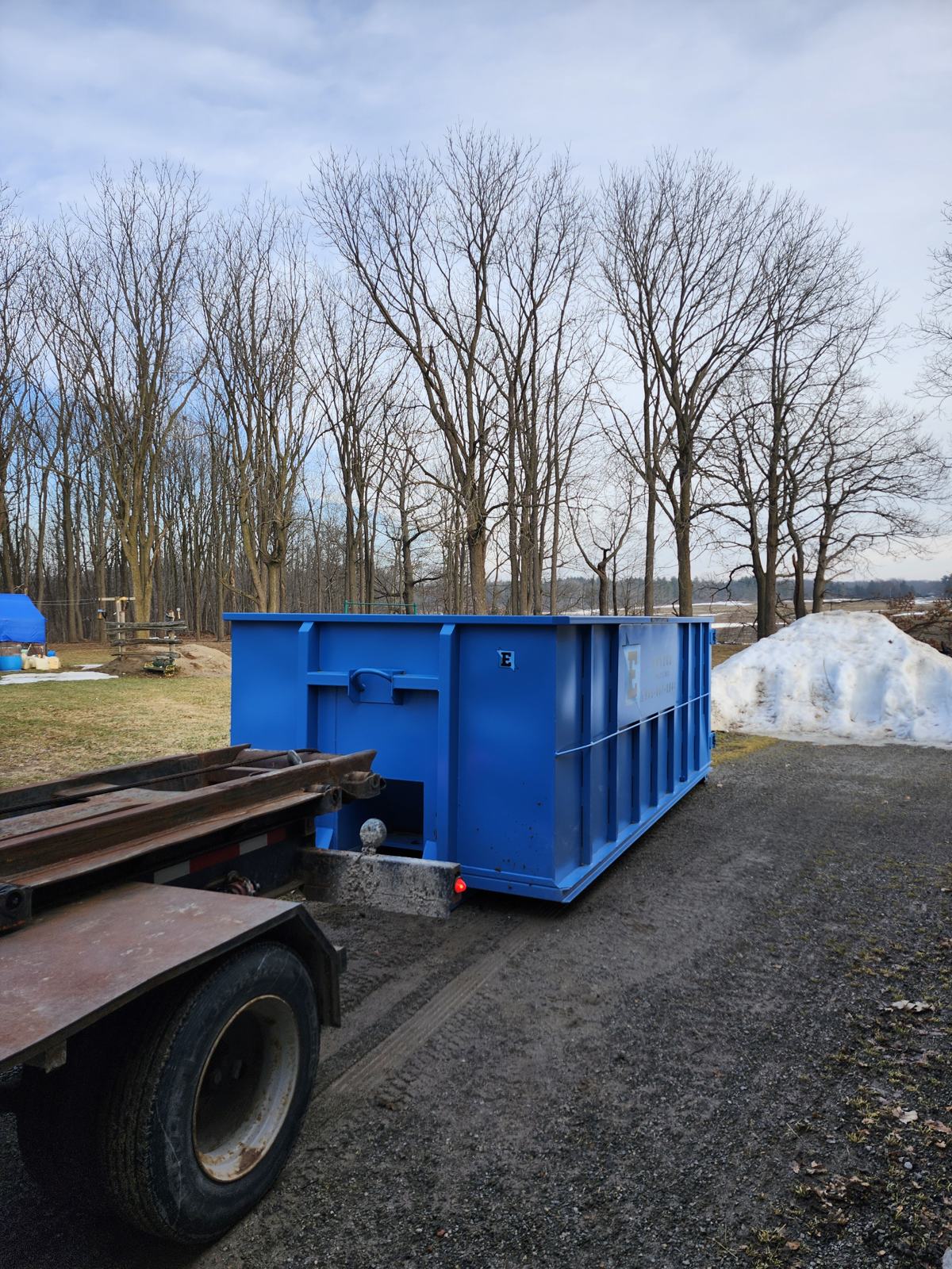 Eastco Hauling roll-off bin beside a building
